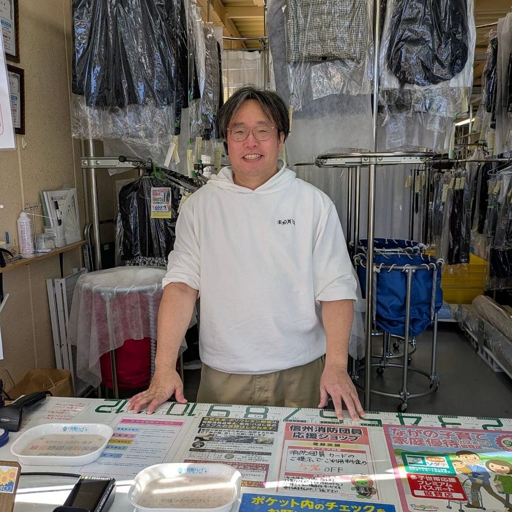 クリーニングひまわりの店内受付カウンターに立つ店主(長野県佐久市)