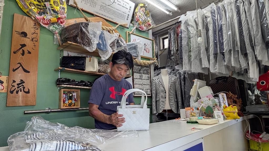 お客様の大切なバッグを丁寧に確認する店主