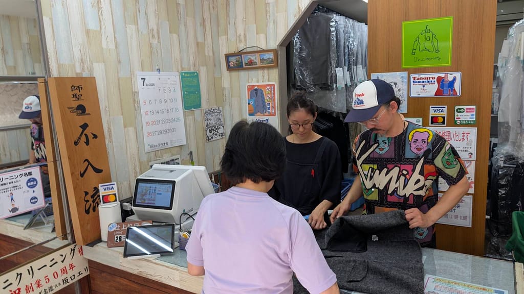 スーツの状態を確認するクリーニング店。写真提供:ユニクリーニング中町店