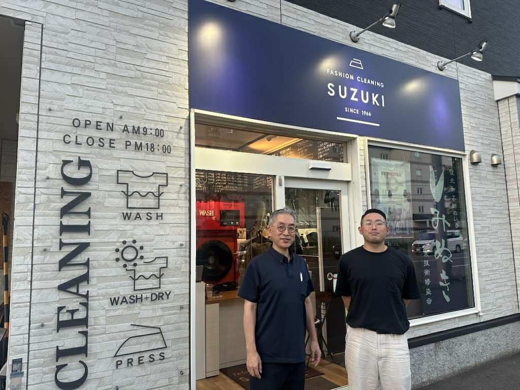 札幌のファッションクリーニングSuzuki.の店舗前で、店主と後継の息子が並んで写っている記念写真。