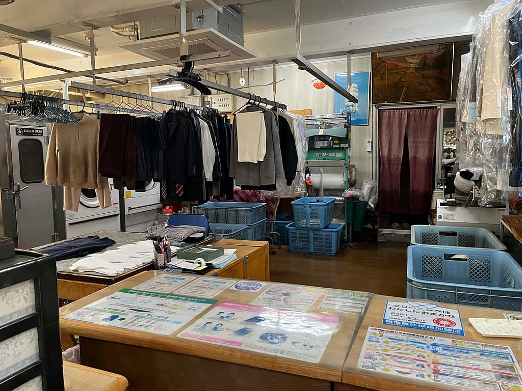 浜屋クリーニングの店内全景(受付と衣類ラック・作業スペース)
