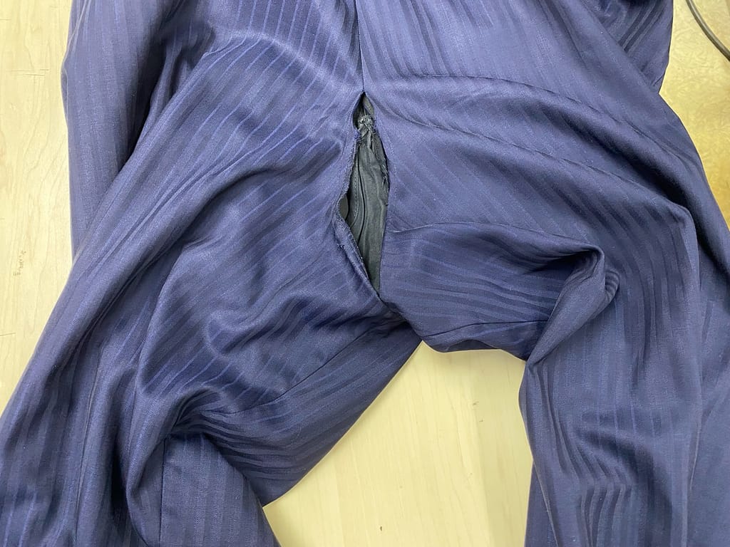 股部分が破損したスラックスのクリーニング前の状態