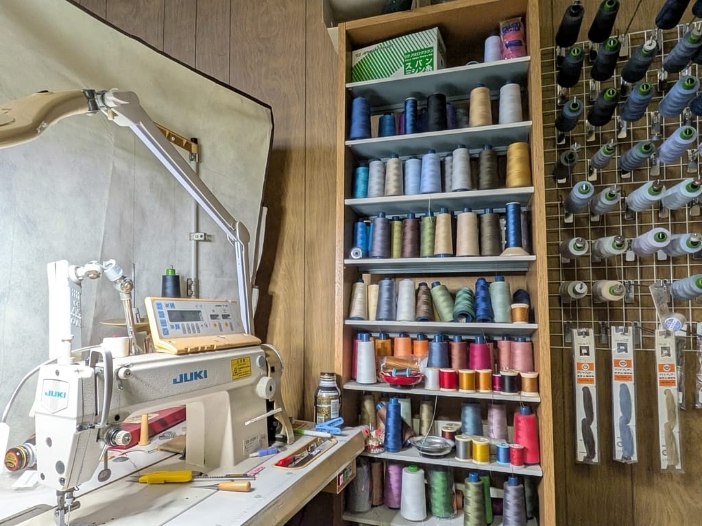 衣類のお医者さん クリーニングオオタ お直し用ミシンと色糸棚 修理対応設備