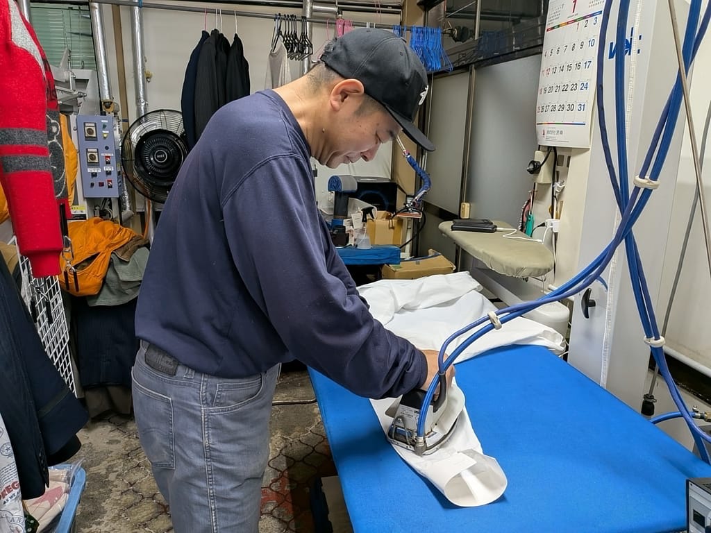 衣類のお医者さん クリーニングオオタ 店主によるアイロン仕上げ作業風景