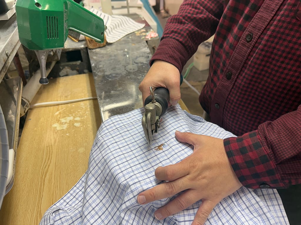 みつぼしクリーニングのしみ抜き作業(衣類の汚れを確認する手元)