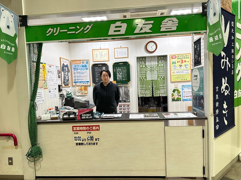 白友舎 ぷらっとてついち店の受付カウンターに立つ店長(室蘭市輪西町)
