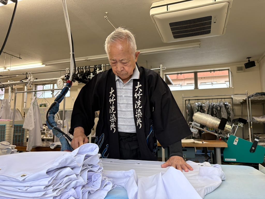 大竹クリーニング店でアイロン仕上げを行う会長