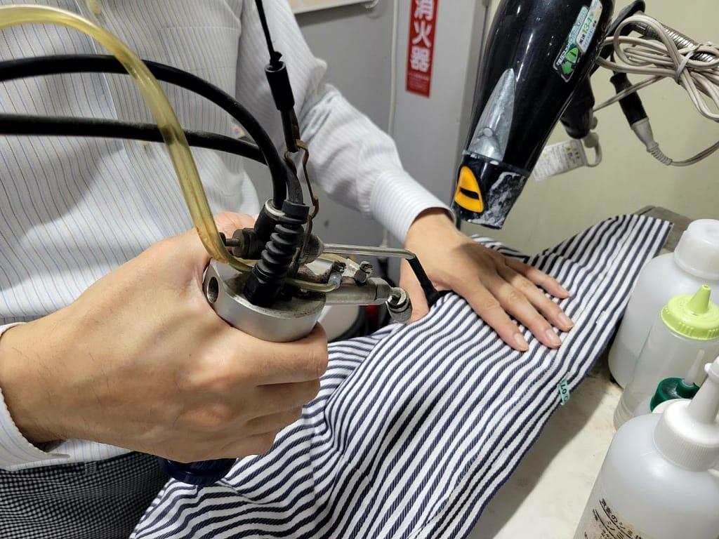 衣類の状態を確認しながら行うしみ抜き作業