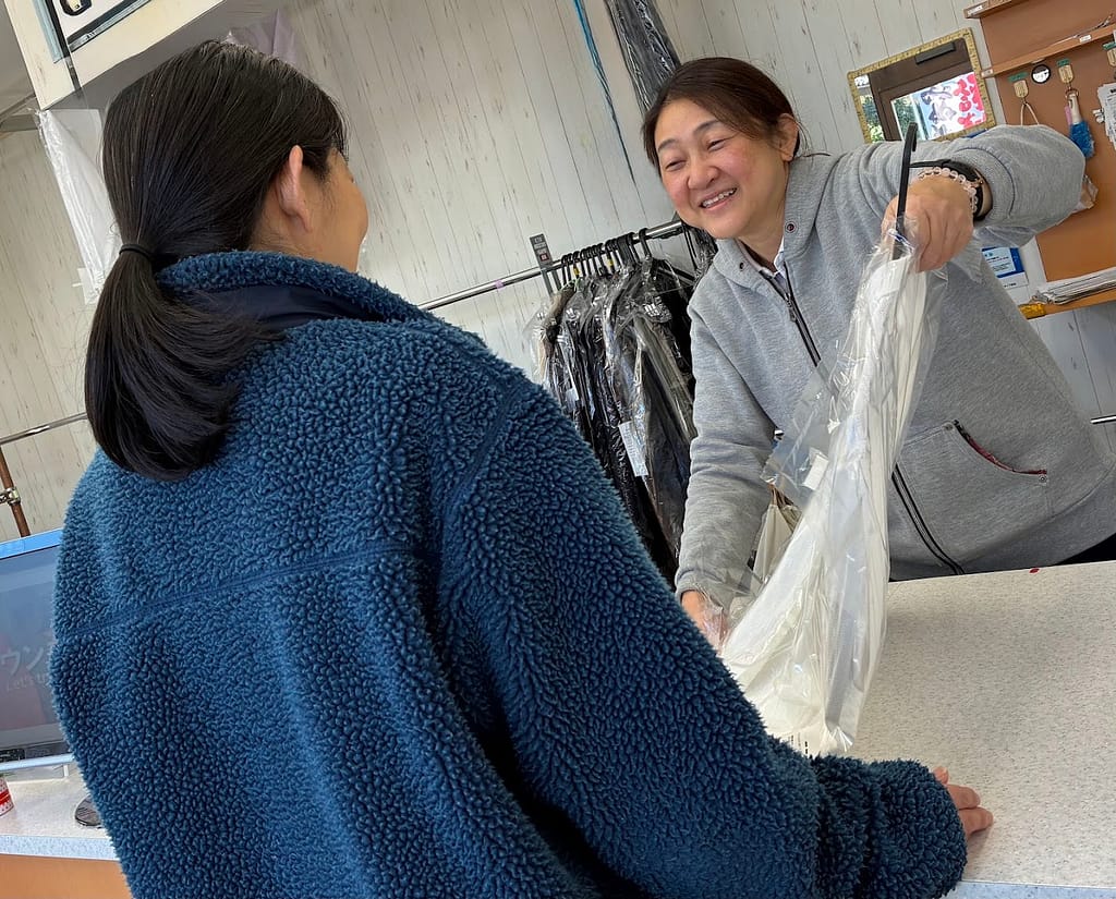 藤沢市のクリーニングアンジェで接客対応をする社長