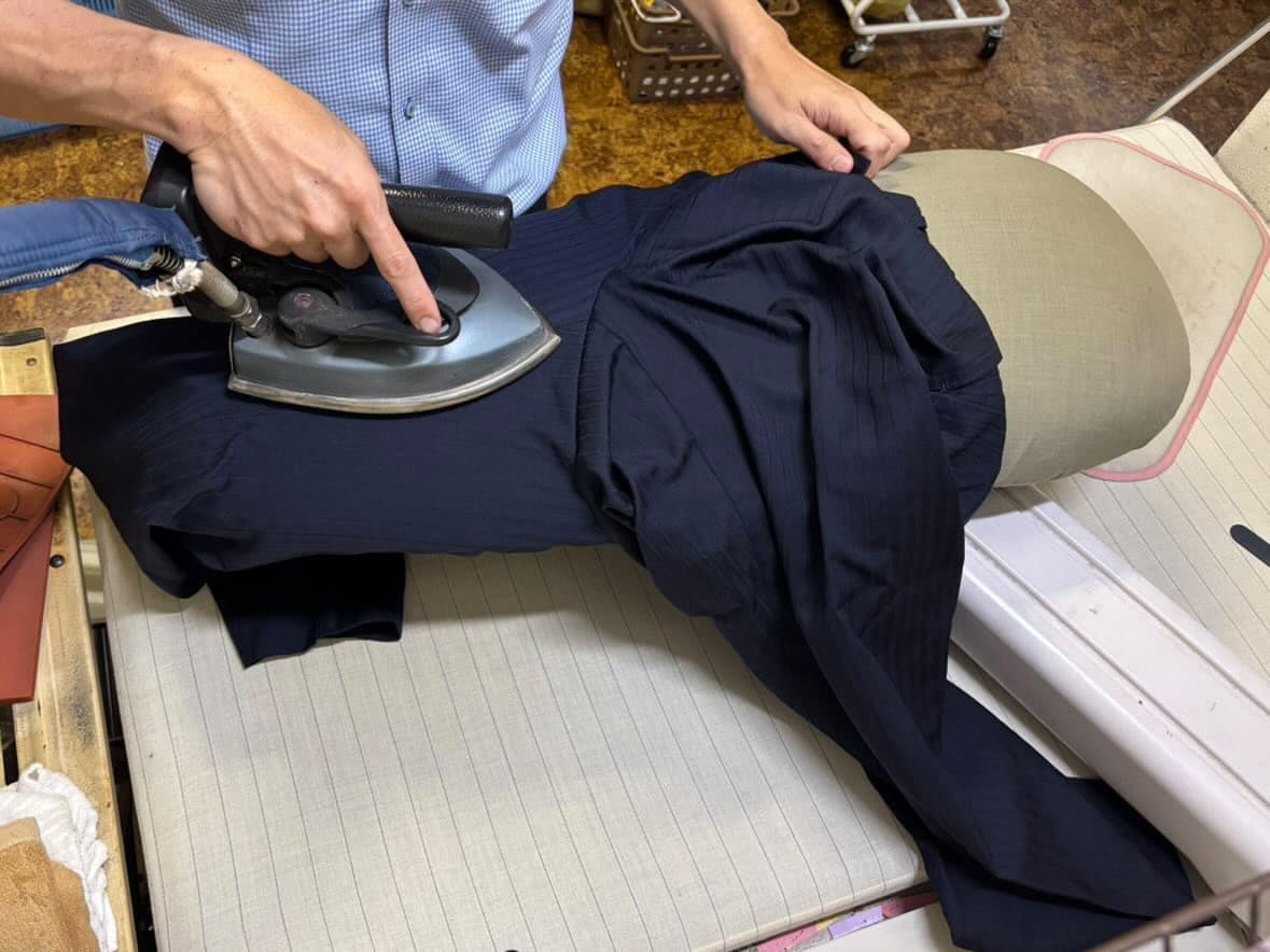 岡田クリーニング店（吾川郡いの町）の店主による学生服のアイロン作業風景