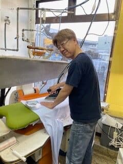 白洗舎クリーニング(さいたま市見沼区)店主のプレス作業風景