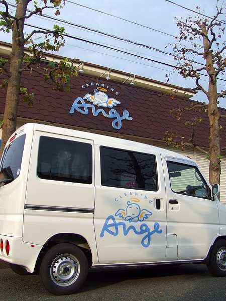 クリーニングアンジェの配達車と店舗ロゴ