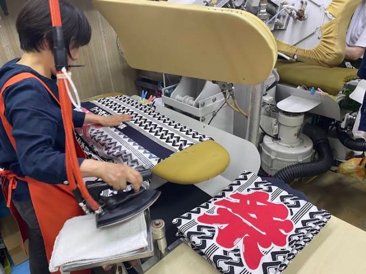 祭り衣装を丁寧にプレス仕上げするグレースクリーニング権太坂店の作業風景