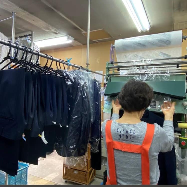 仕上がった衣類を丁寧に包装するグレースクリーニング権太坂店の作業風景