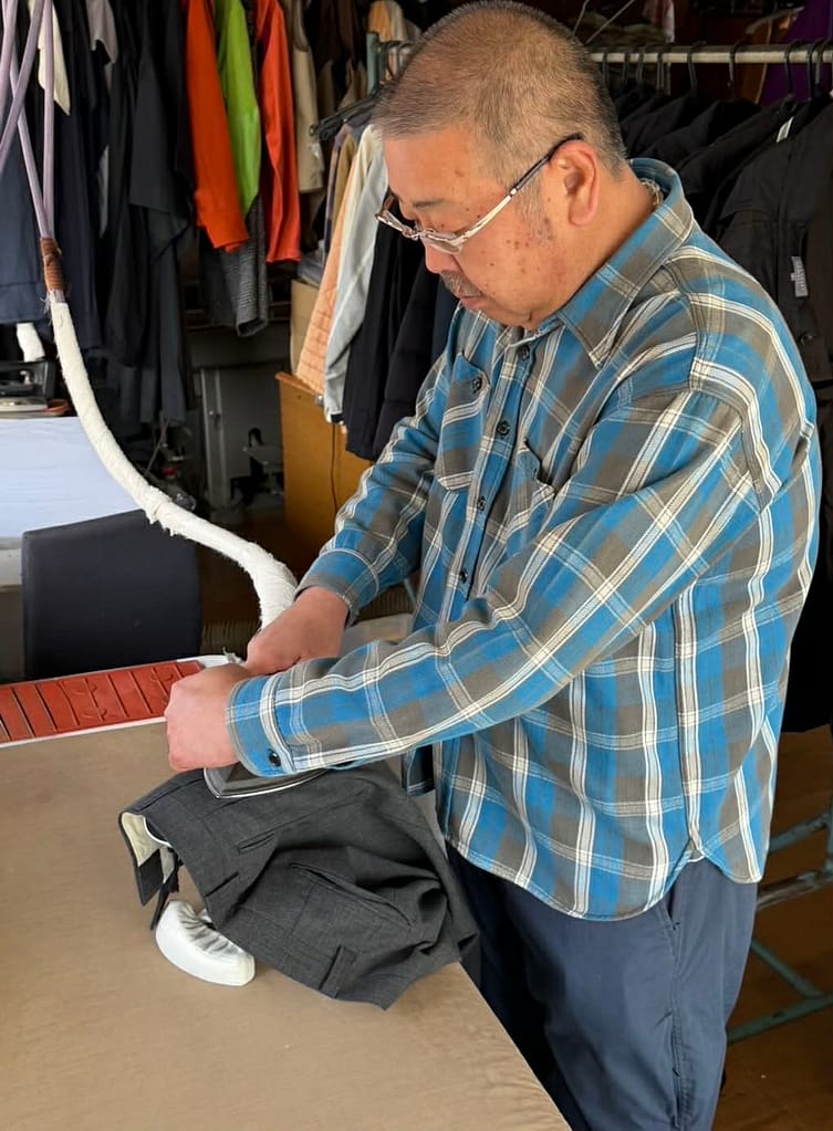 スーツをアイロン仕上げする作業風景