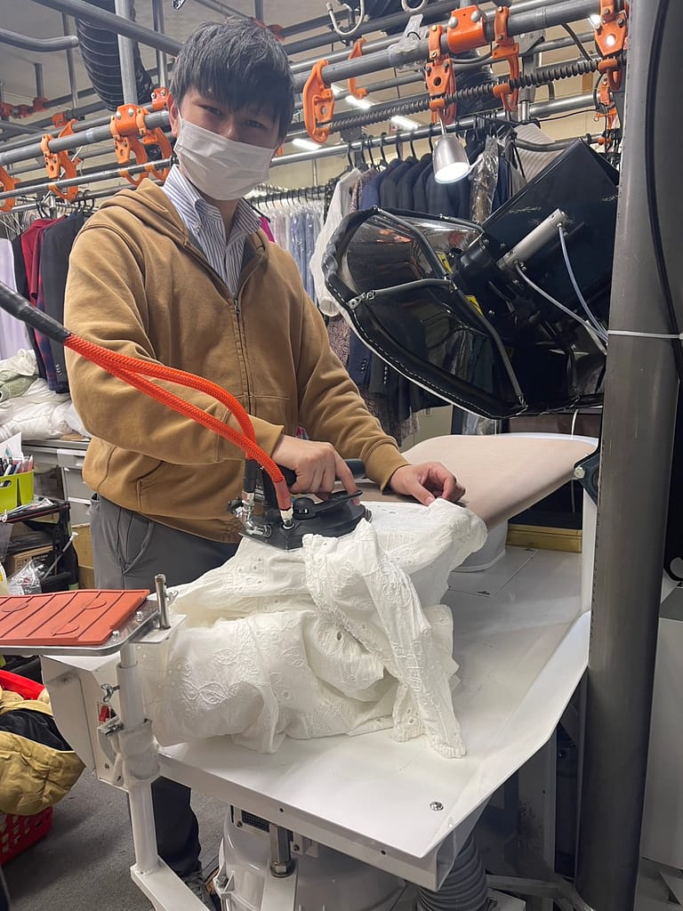 クリーニングうみのでアイロン仕上げを行うスタッフのダイスケさん