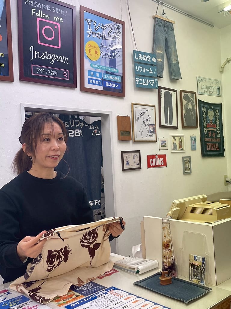 お客様の衣類を手に説明する染み抜き専門店アイチャク284の店主