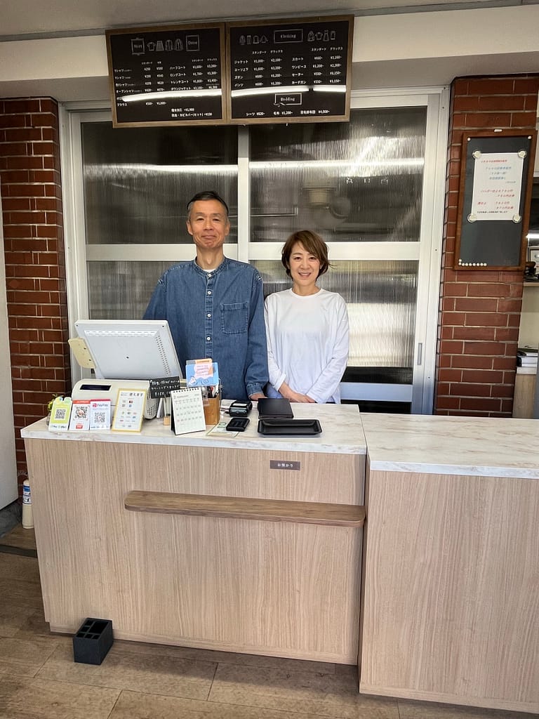 松野クリーニング本店の受付カウンターに立つ三代目店主ご夫婦