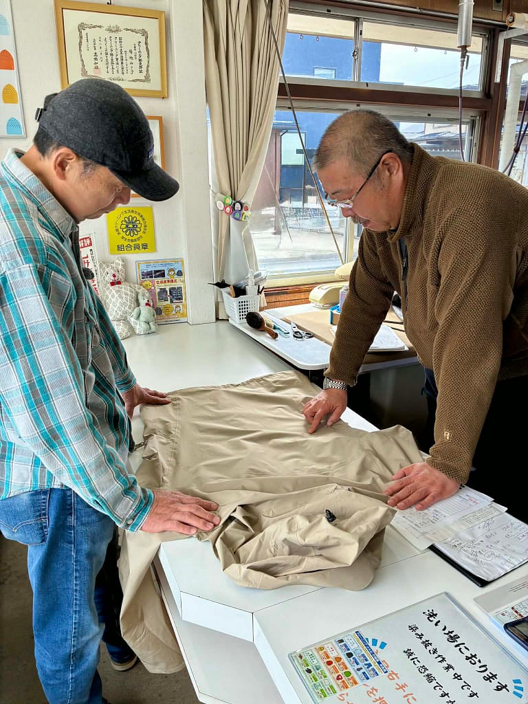 店内で衣類の状態を確認しながら相談する様子