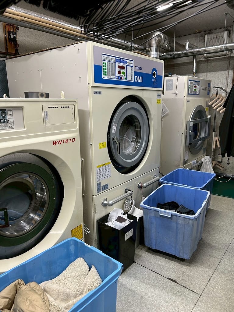 業務用洗濯機が並ぶクリーニングコマツの工場設備