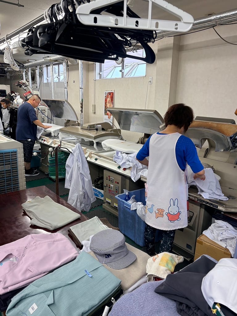 大竹クリーニング店で衣類を仕上げるスタッフ
